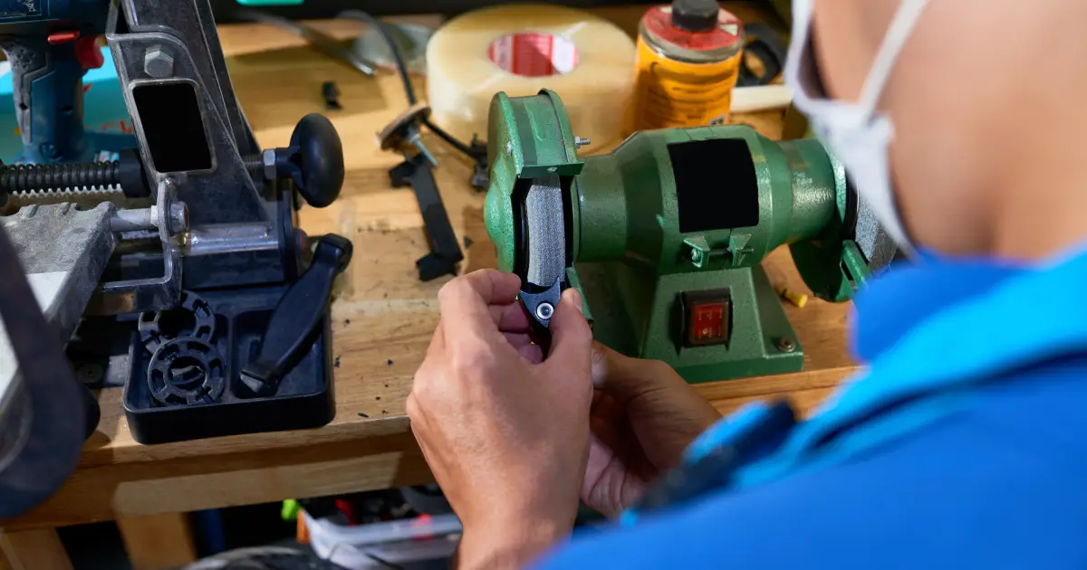 Technician performing electric motor preventive maintenance by inspecting and servicing motor components in a workshop