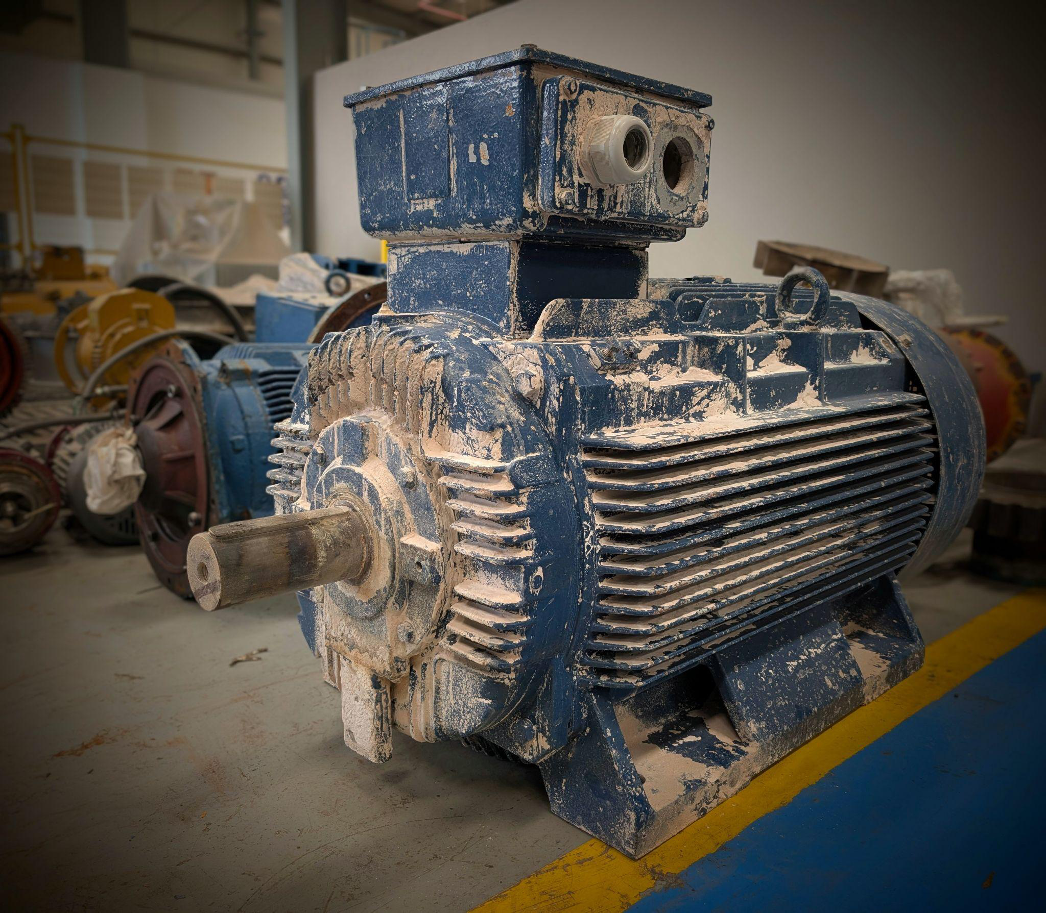 Dust-covered industrial electric motor at cement plant ready for overhauling