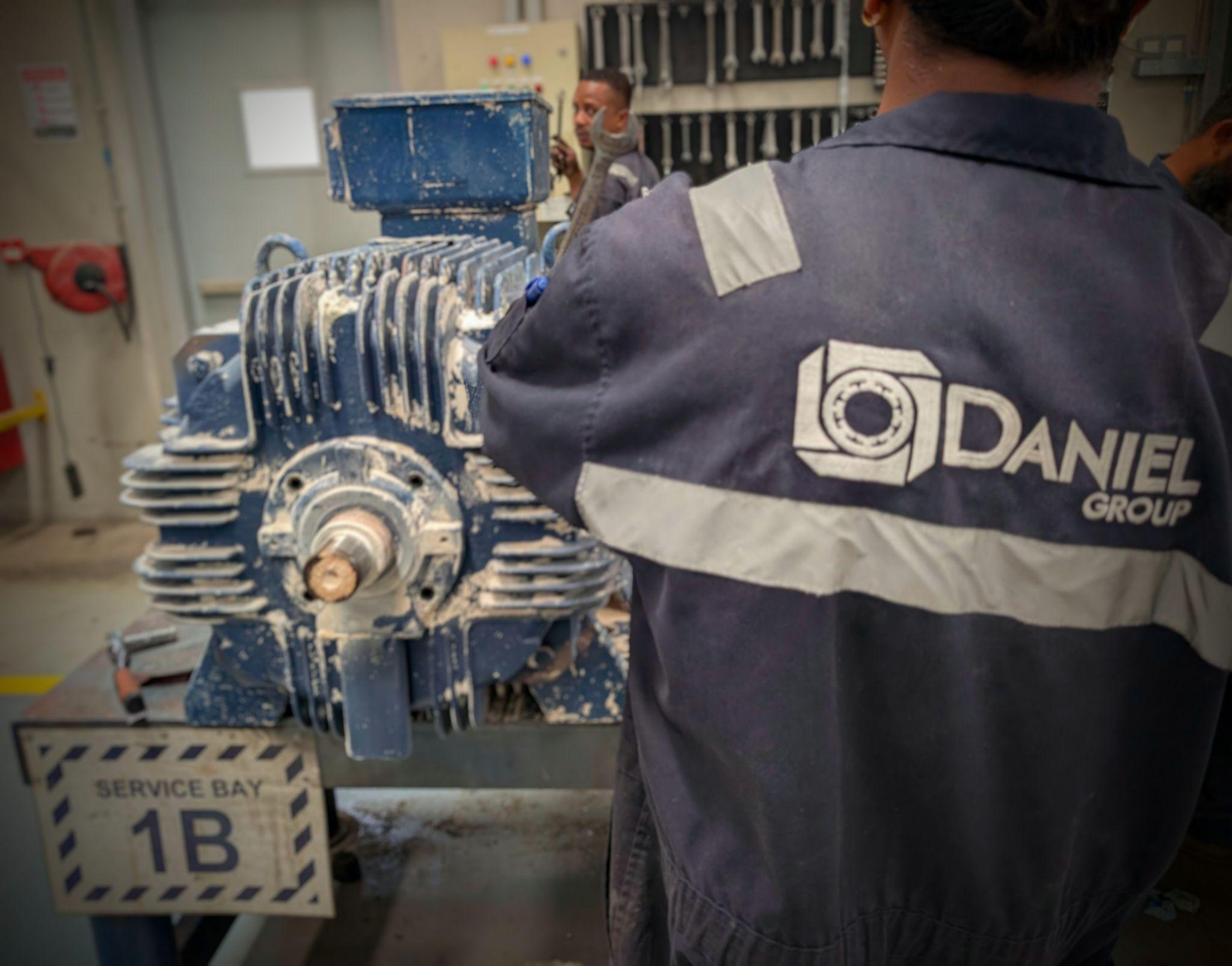 Daniel Group engineer inspecting industrial electric motor at workshop Service Bay 1B