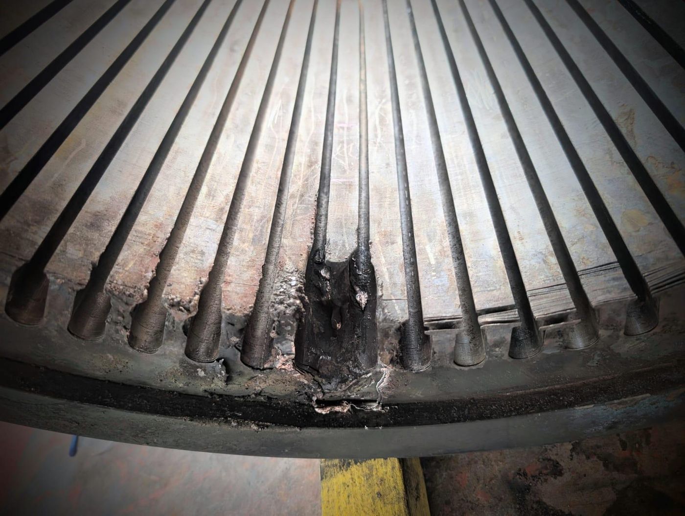 Burnt and shorted stator core laminations at the base of a large electric motor slot