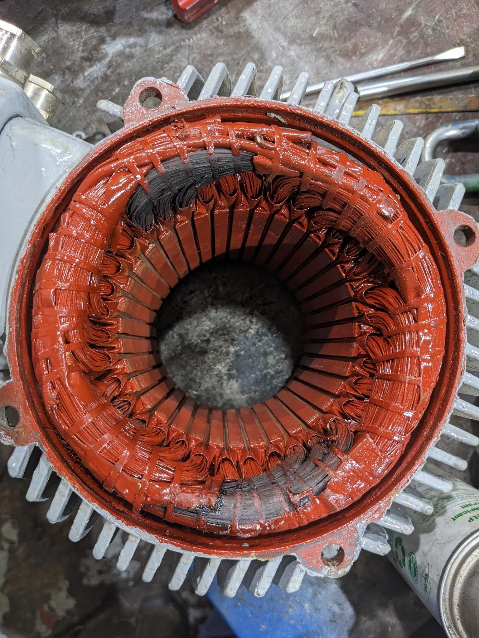 Burnt electric motor stator windings showing localised overheating and insulation damage caused by single phasing