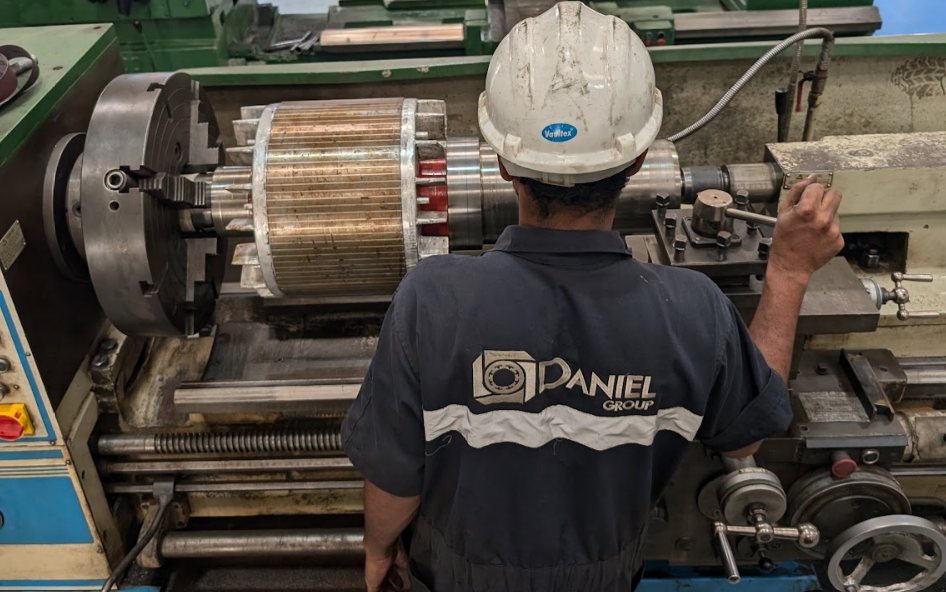 Daniel Group technician machining a motor rotor on a lathe in the machine shop