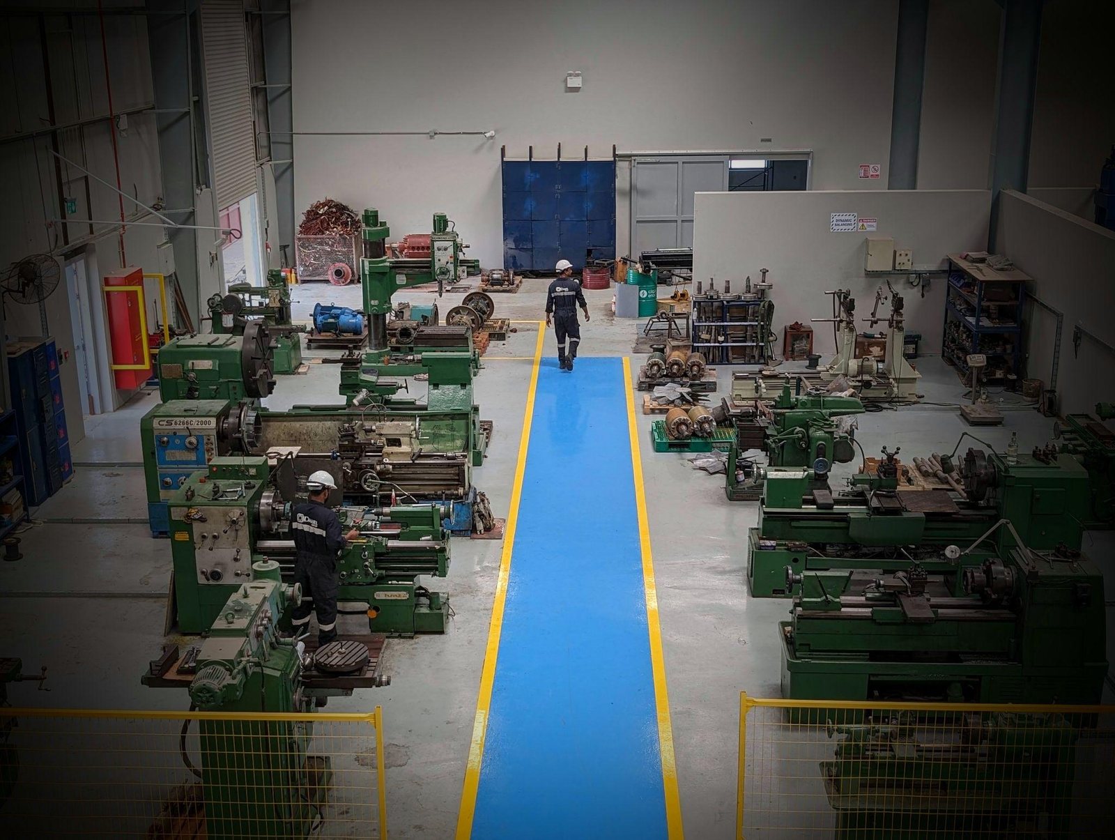 Integrated machine shop and fabrication workshop with rows of lathes and machining equipment